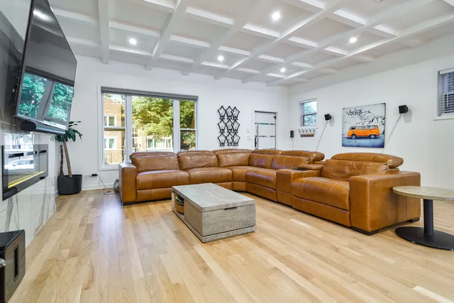a living room with furniture a flat screen tv and a large window