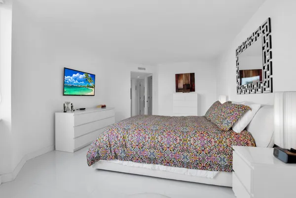 a bedroom with a bed and a flat screen tv