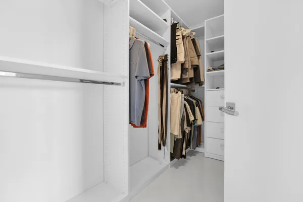 a view of walk in closet with clothes
