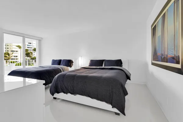 a bedroom with two beds and a large window