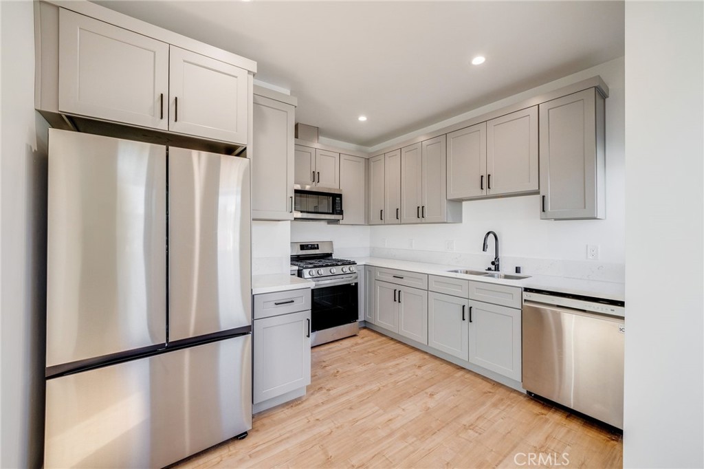 a kitchen with white cabinets and stainless steel appliances