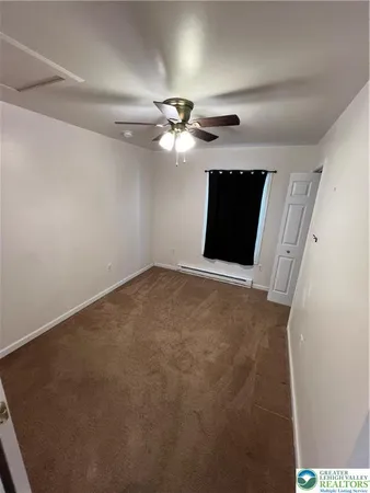 en empty room with windows and fan