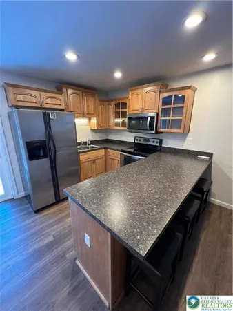 a kitchen with stainless steel appliances granite countertop a sink dishwasher stove and refrigerator