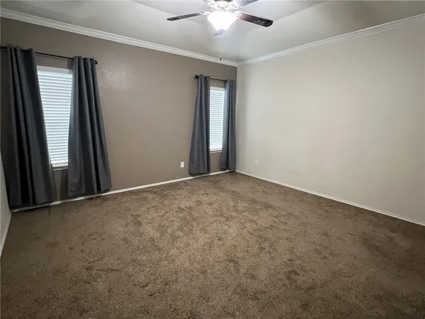 an empty room with windows and fan