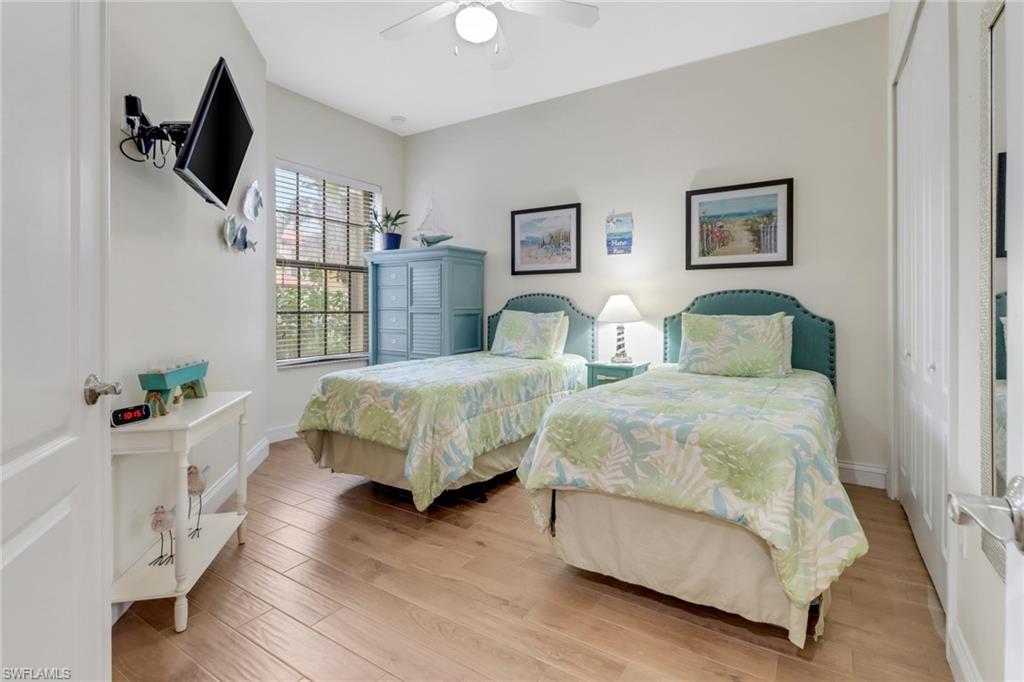 1296 Verde Drive, Unit 3 Naples, FL 34105 - Photo 19 of 31 a bedroom with a bed a flat screen tv and a window