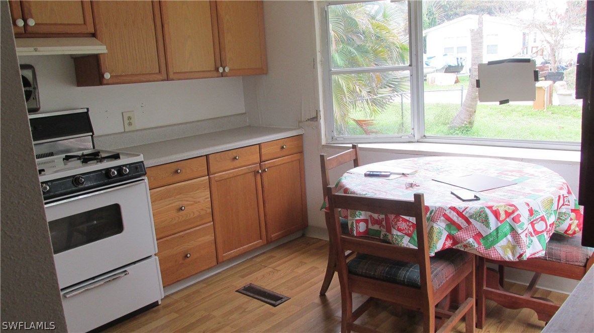 7301 Pinehurst Road Bokeelia, FL 33922 - Photo 4 of 11 a kitchen with a wooden floor and a stove top oven