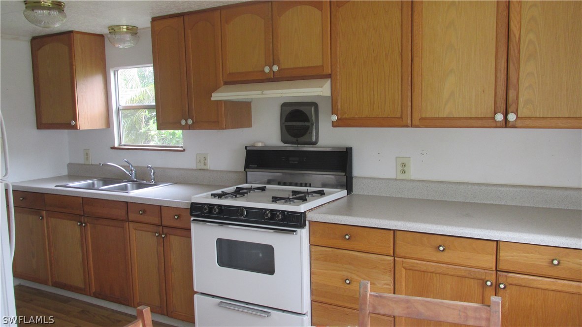 7301 Pinehurst Road Bokeelia, FL 33922 - Photo 5 of 11 a kitchen with stove top oven sink and cabinets