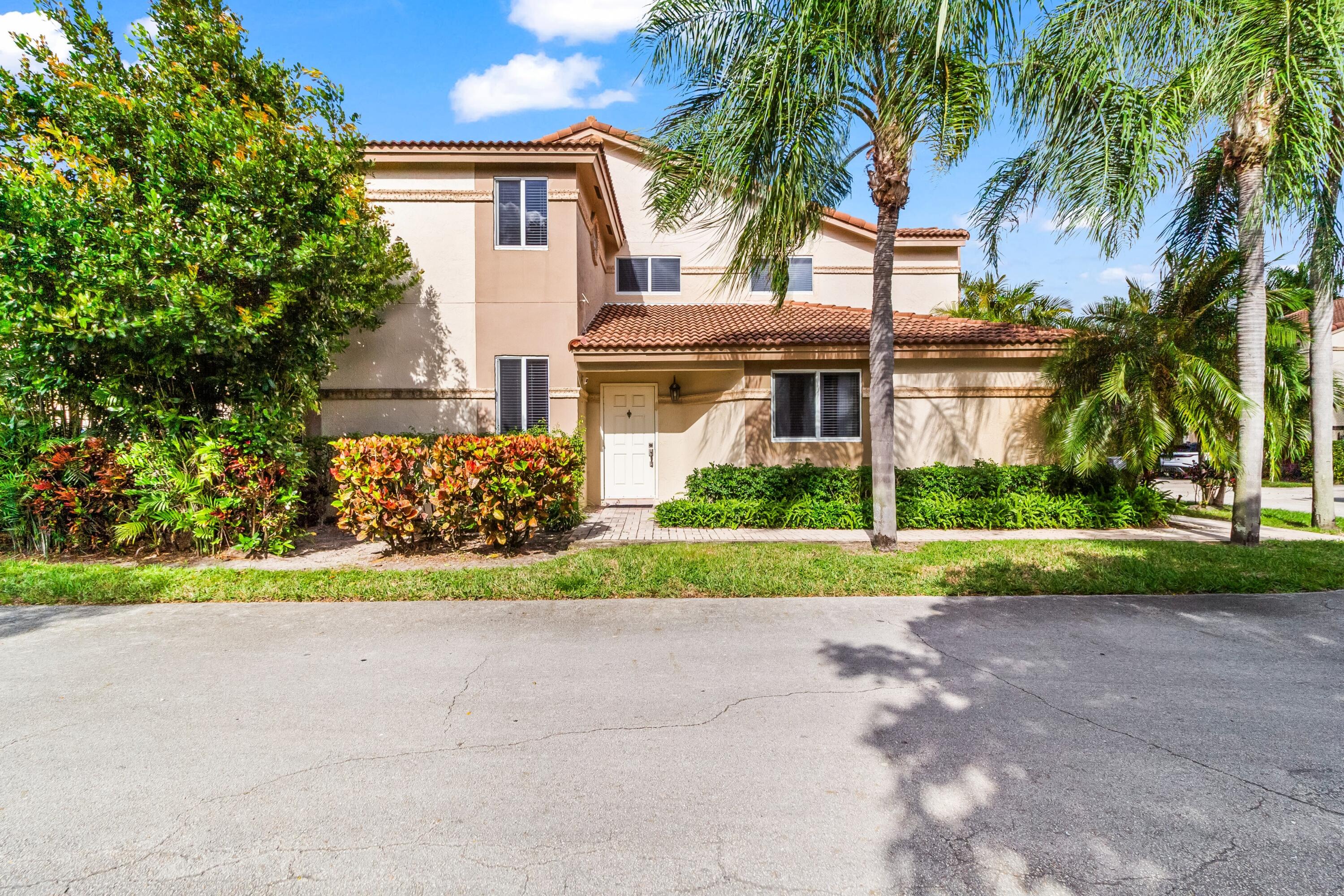 6700 Via Regina Boca Raton, FL 33433 - Photo 1 of 15 front view of house with a yard and palm trees
