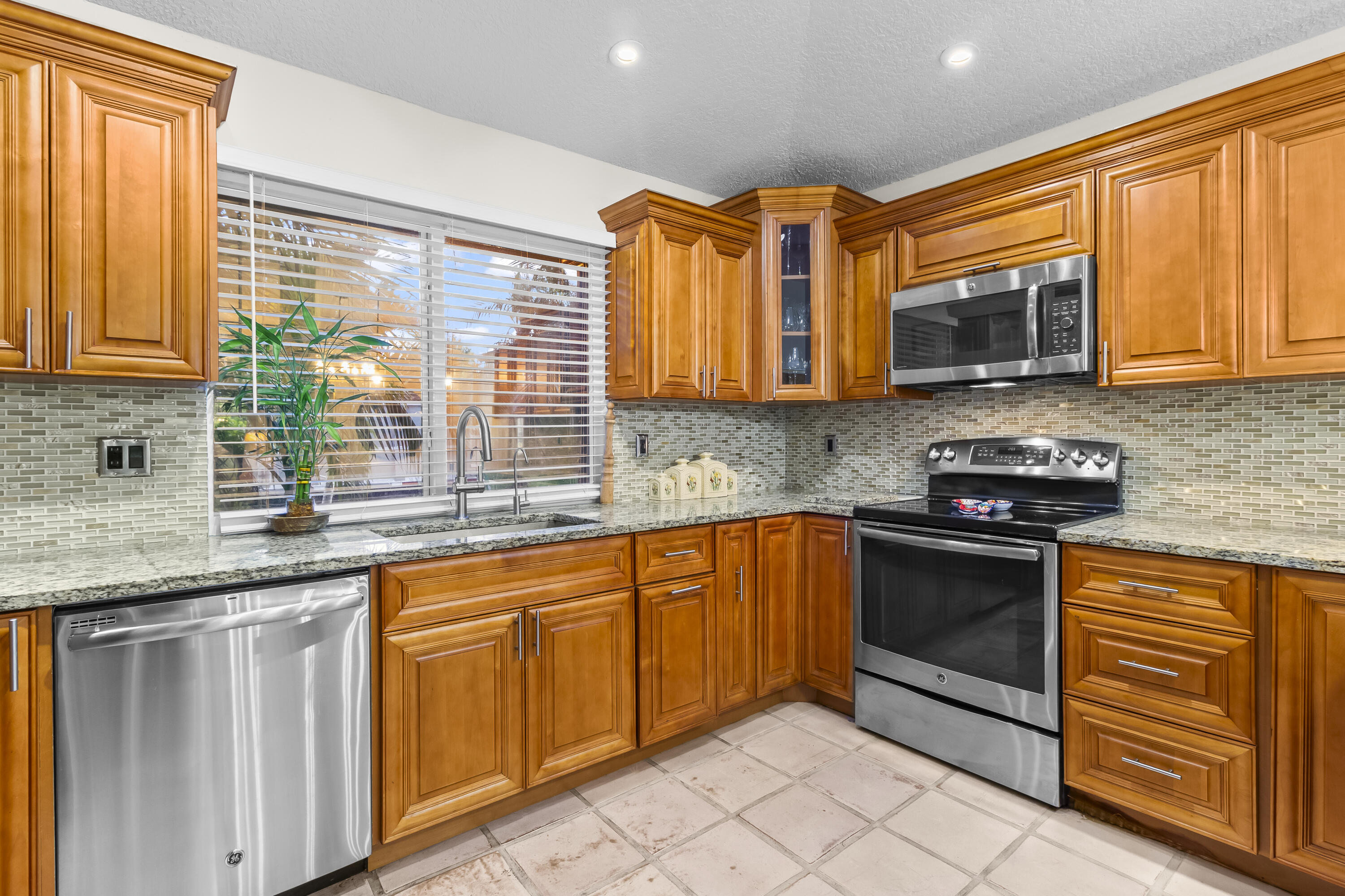 6700 Via Regina Boca Raton, FL 33433 - Photo 3 of 15 a kitchen with granite countertop cabinets stainless steel appliances a sink and a window