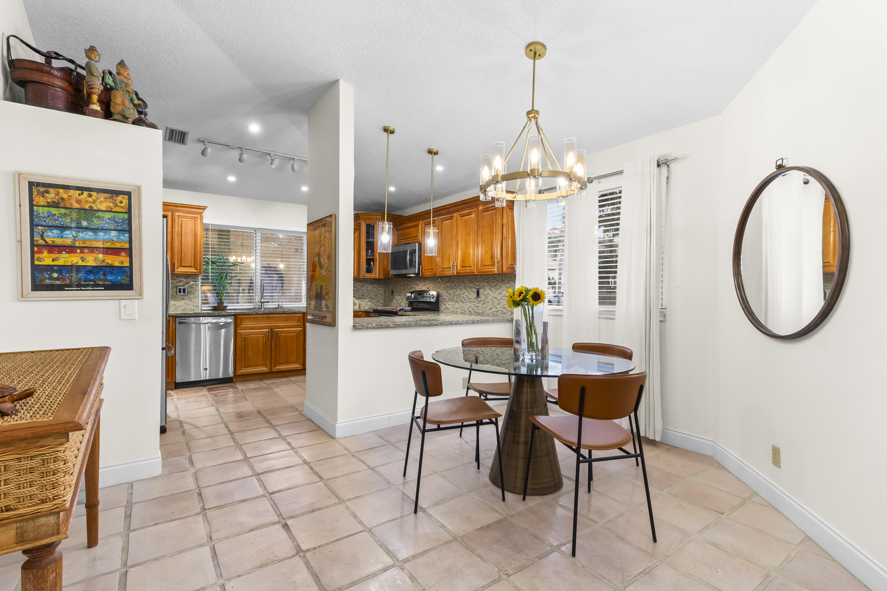 6700 Via Regina Boca Raton, FL 33433 - Photo 6 of 15 a dining hall with stainless steel appliances kitchen island granite countertop a table and chairs in it