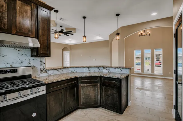 a kitchen with stainless steel appliances granite countertop a sink stove and cabinets