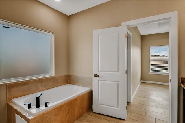 a bathroom with a granite countertop sink a mirror and a bathtub
