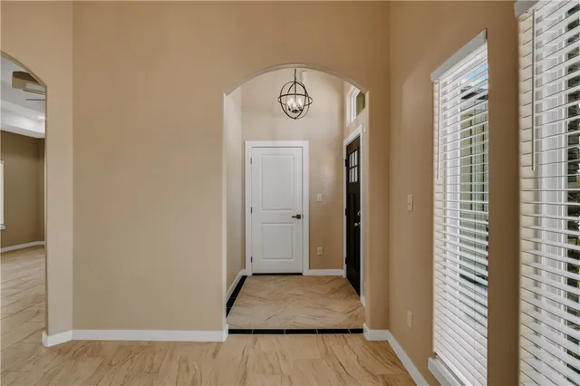 a view of an empty room with a window and a kitchen