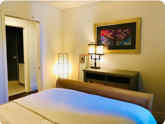 a bedroom with a bed and a painting on the wall