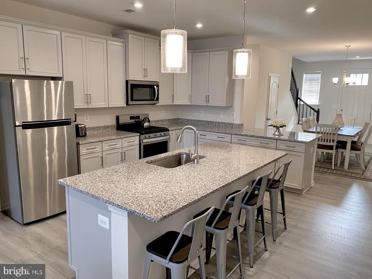 38035 Cross Gate Road Millville, DE 19967 - Photo 3 of 22 a kitchen with stainless steel appliances granite countertop a kitchen island hardwood floor and a sink