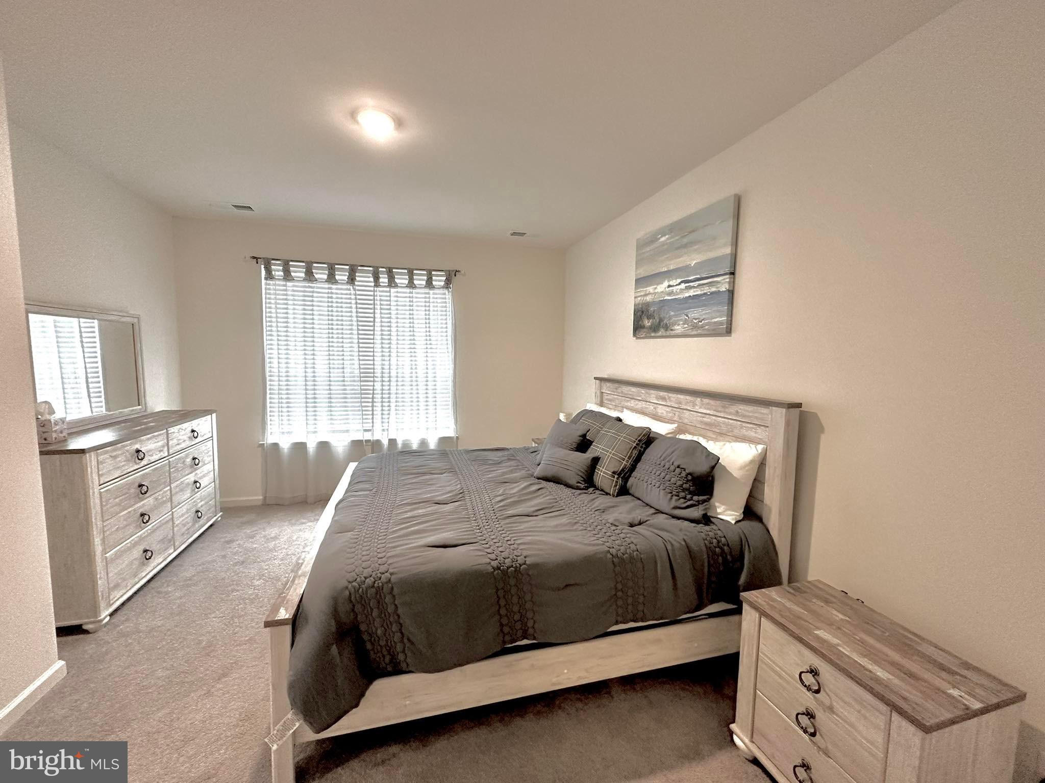 38035 Cross Gate Road Millville, DE 19967 - Photo 9 of 22 a bedroom with a bed and a dresser next to a window