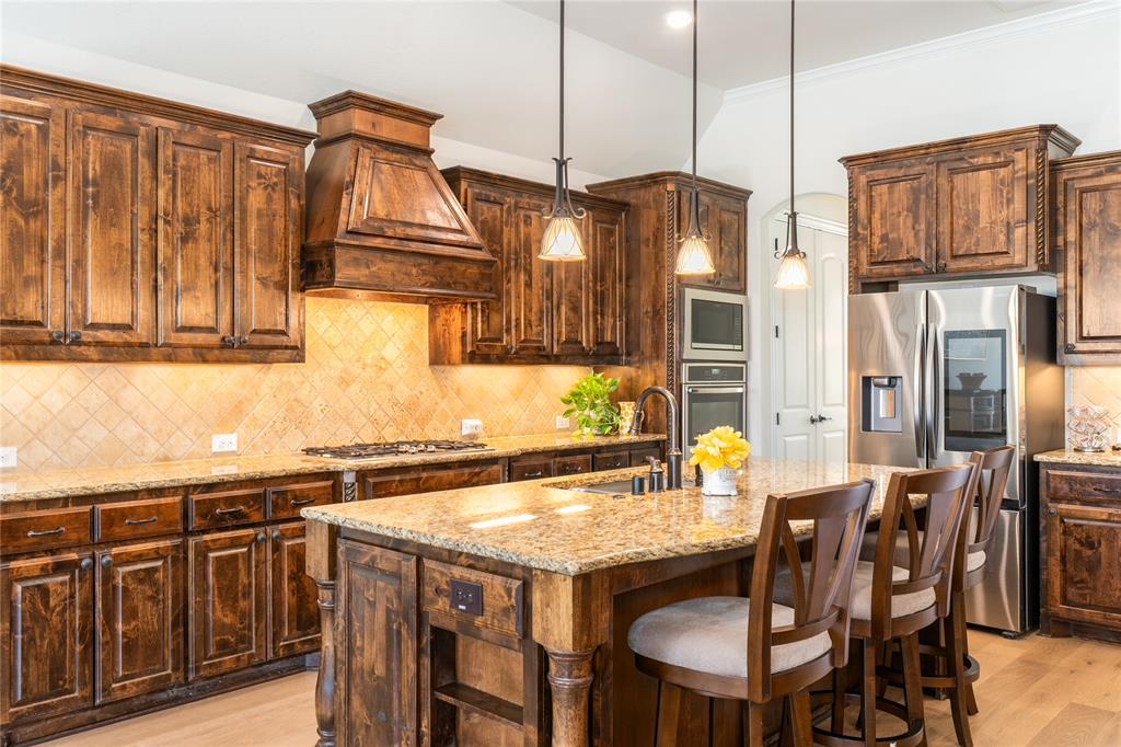 1112 Rhett Drive Colleyville, TX 76034 - Photo 9 of 40 a kitchen with stainless steel appliances granite countertop a kitchen island a stove a dining table and chairs