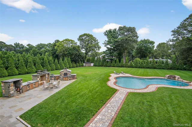 a bathroom with a granite countertop sink double vanity mirror and bathtub