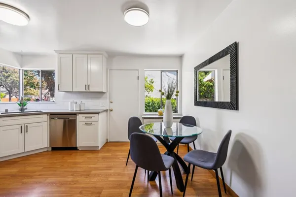 a kitchen with cabinets stainless steel appliances a sink and wooden floor