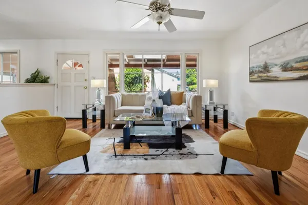 a living room with furniture and a wooden floor