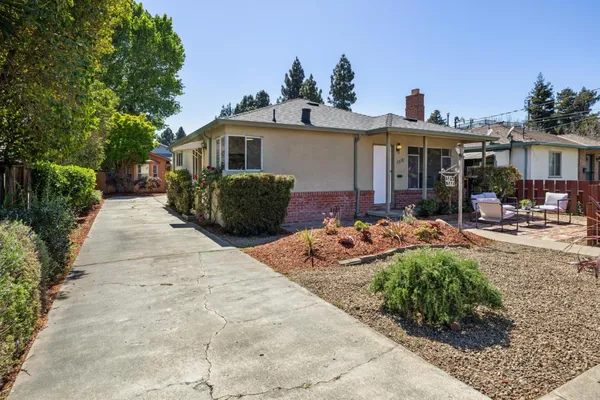 a view of backyard with outdoor seating and plants