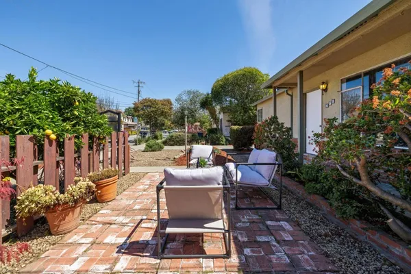 a view of a patio with couches and table and chairs and potted plants