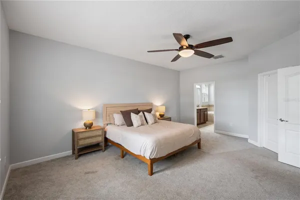 a bedroom with a bed and a ceiling fan