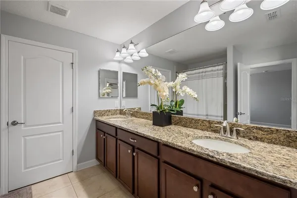 a bathroom with a granite countertop sink and a mirror