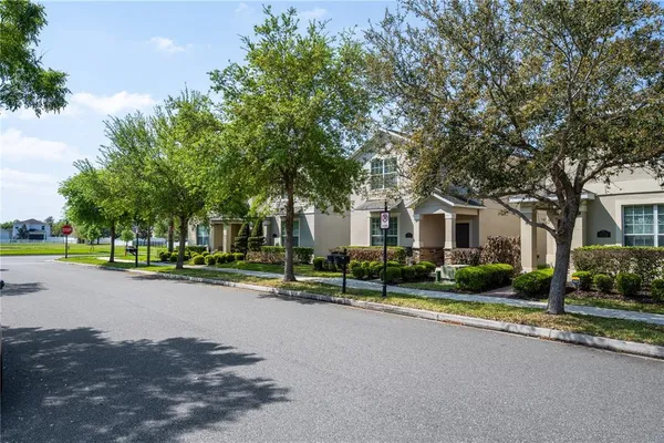 a view of a house with a big yard and large trees