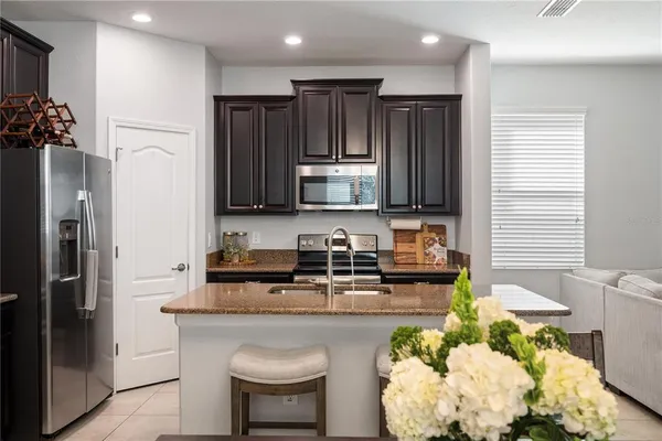 a kitchen with stainless steel appliances granite countertop a refrigerator sink and stove