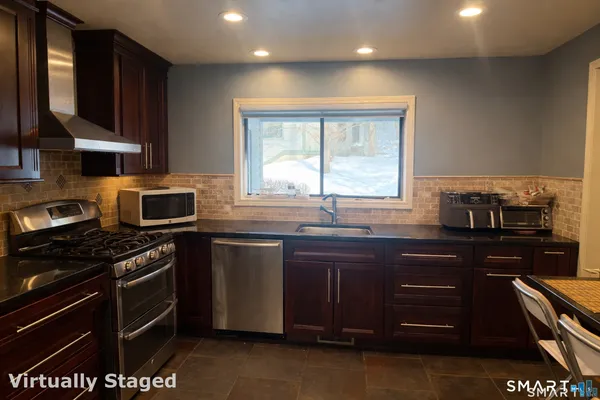 a kitchen with stainless steel appliances granite countertop a refrigerator and a stove top oven