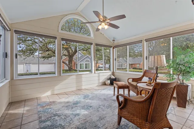 a living room with furniture a floor to ceiling windows and a flat screen tv