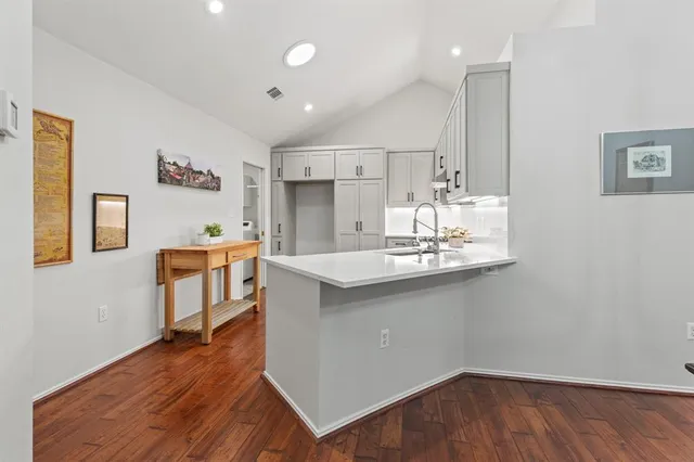 a kitchen with kitchen island a sink cabinets and wooden floor