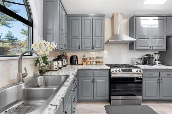 a kitchen with stainless steel appliances granite countertop a sink stove and cabinets