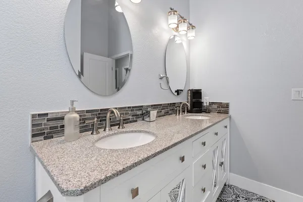 a bathroom with a granite countertop sink a mirror and vanity
