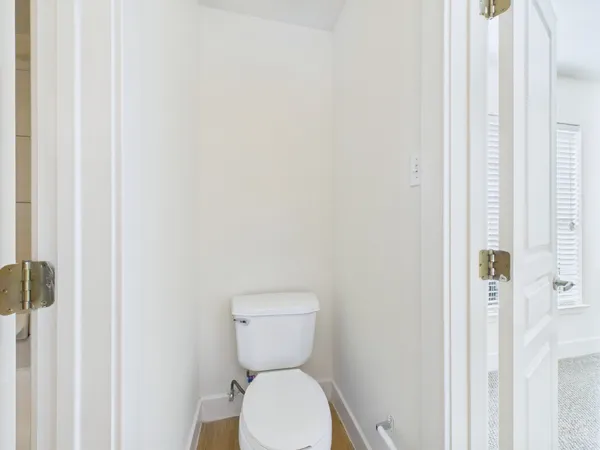 a white toilet sitting next to a shower