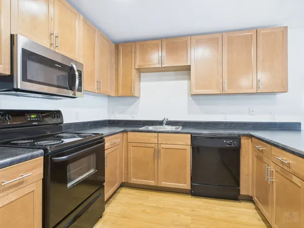 a kitchen with stainless steel appliances granite countertop a stove microwave and sink