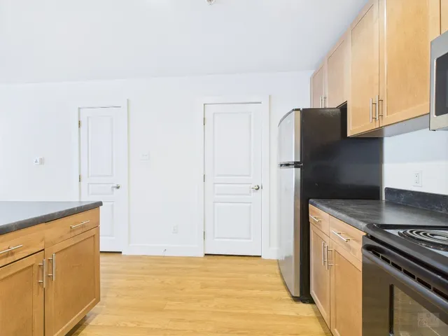 a kitchen with granite countertop a refrigerator stove and sink