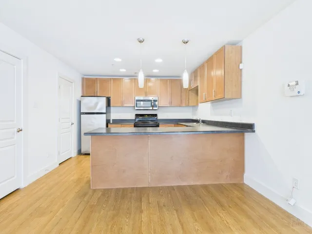a view of kitchen with stainless steel appliances granite countertop refrigerator sink and stove