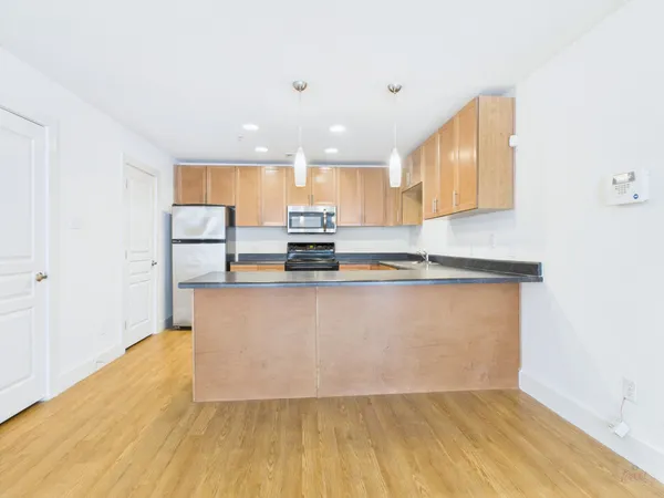 a view of kitchen with stainless steel appliances granite countertop refrigerator sink and stove