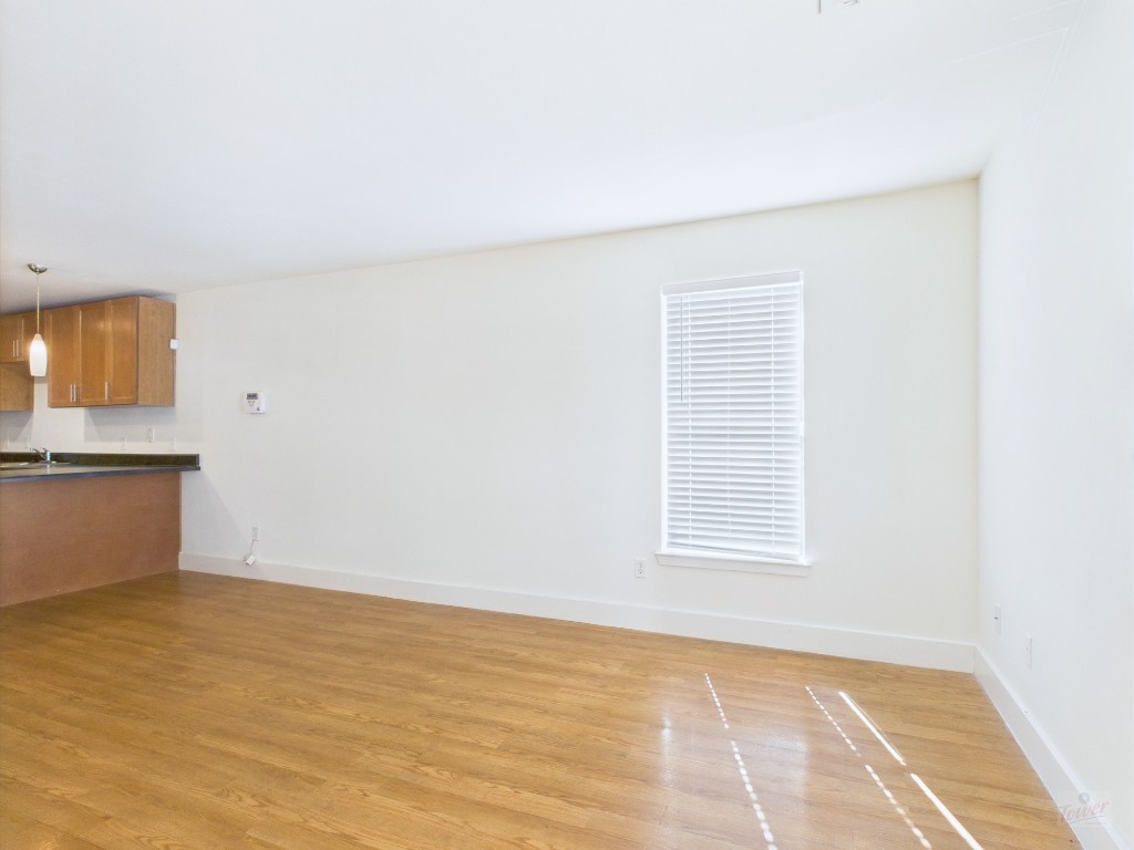 711 West 32nd Street, Unit 151 Austin, TX 78705 - Photo 5 of 21 a view of an empty room with wooden floor and a window