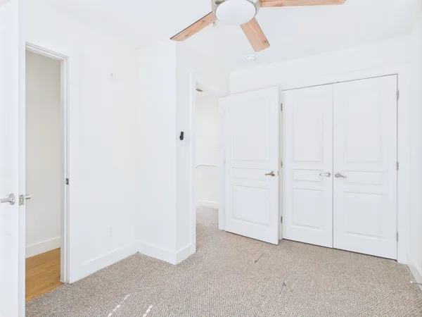 a view of a closet area with ceiling fan