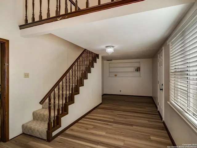 a view of a hallway with wooden floor and staircase