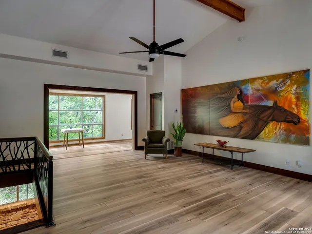 a view of a livingroom with furniture wooden floor a ceiling fan and a window