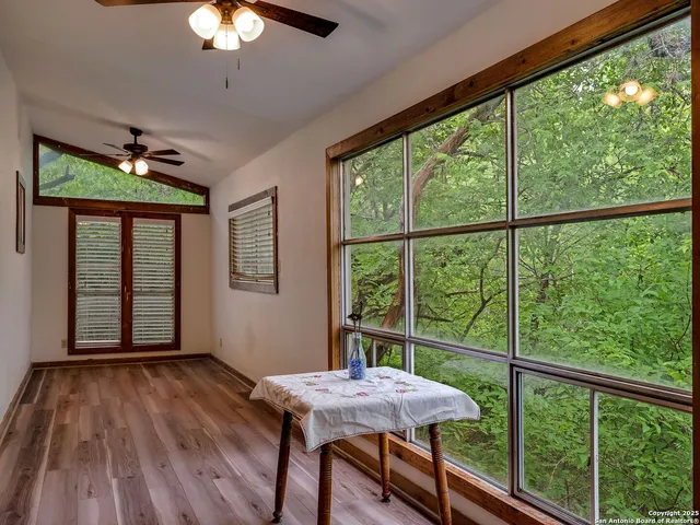 a view of a room with a large window and wooden floor