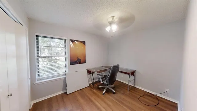 a view of a workspace with furniture and a window