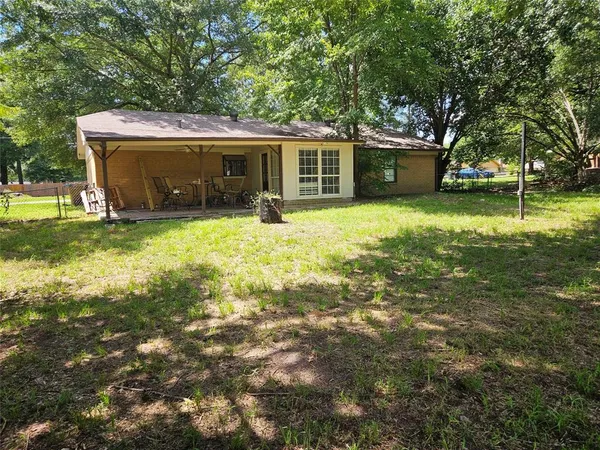 a front view of a house with a garden and trees