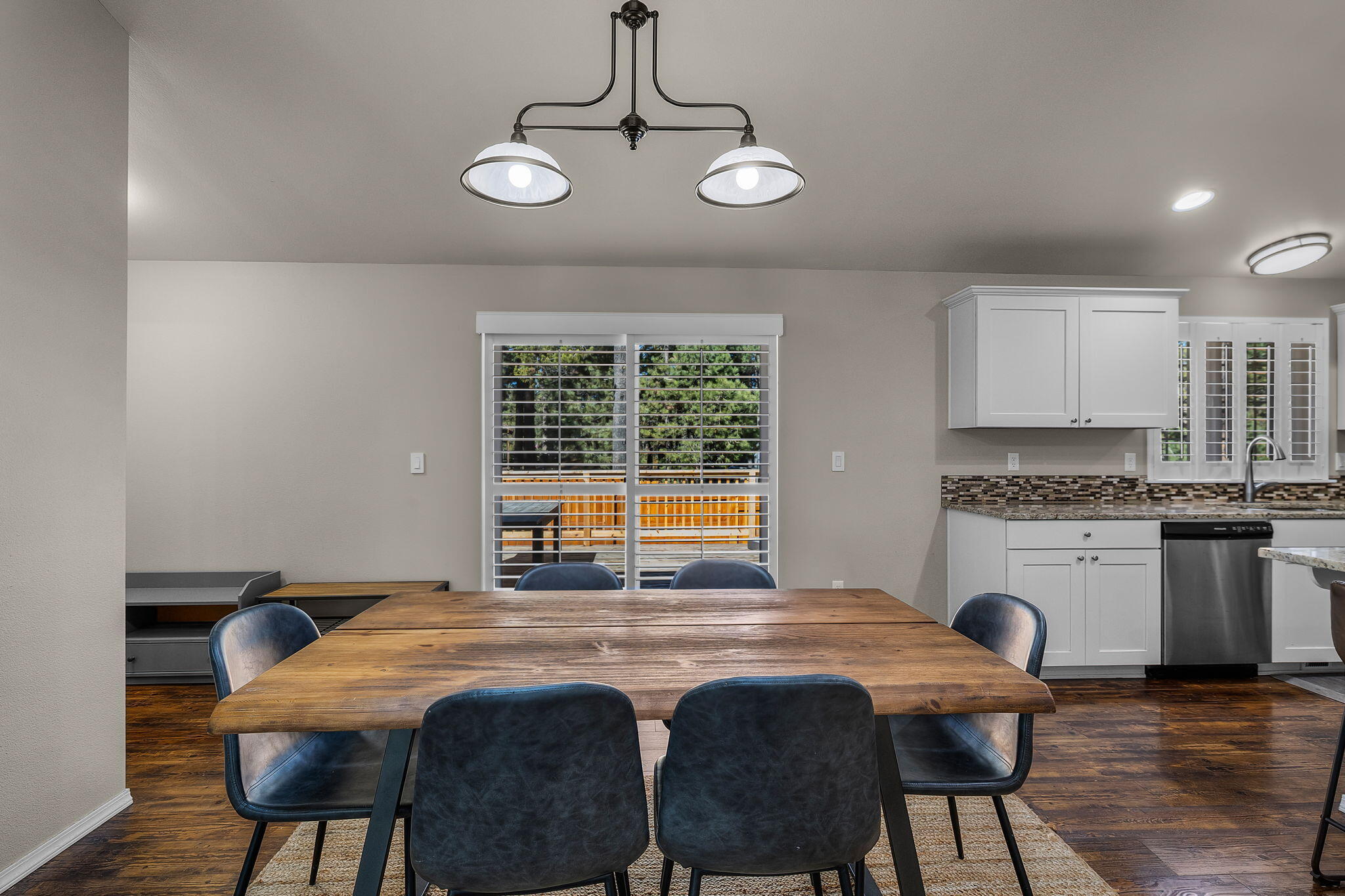 17064 Sacramento Road Bend, OR 97707 - Photo 14 of 50 a kitchen with stainless steel appliances granite countertop a stove a sink dishwasher a dining table and chair with wooden floor