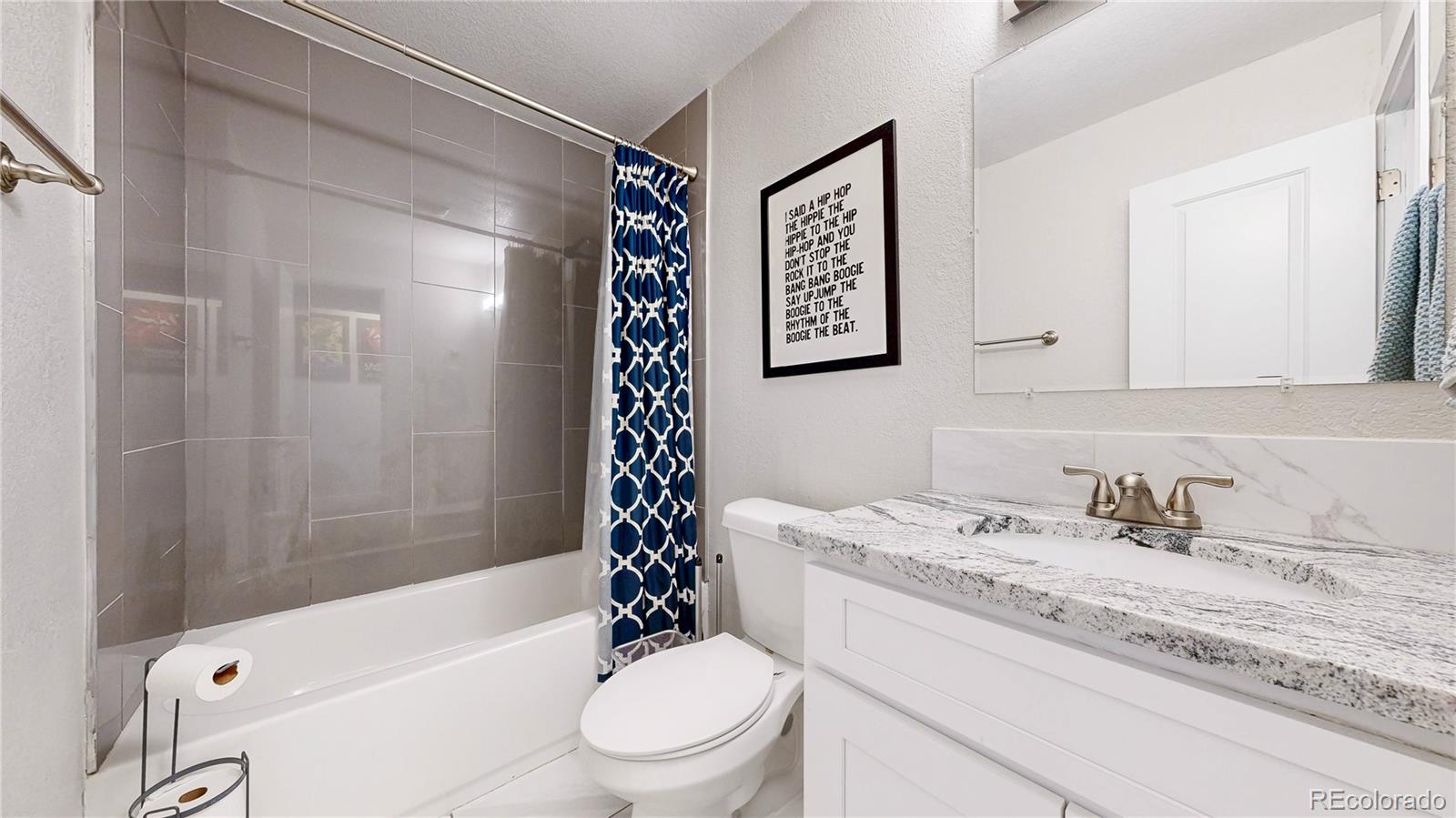 1741 West 55th Place Denver, CO 80221 - Photo 11 of 36 a bathroom with a sink toilet and shower