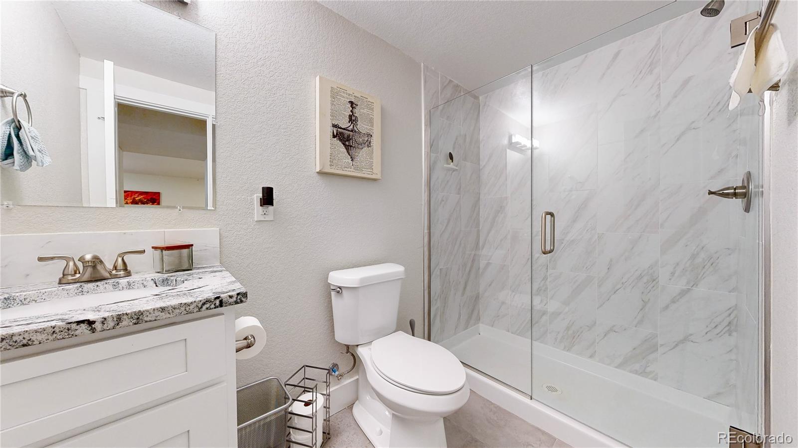 1741 West 55th Place Denver, CO 80221 - Photo 24 of 36 a bathroom with a granite countertop sink toilet and shower